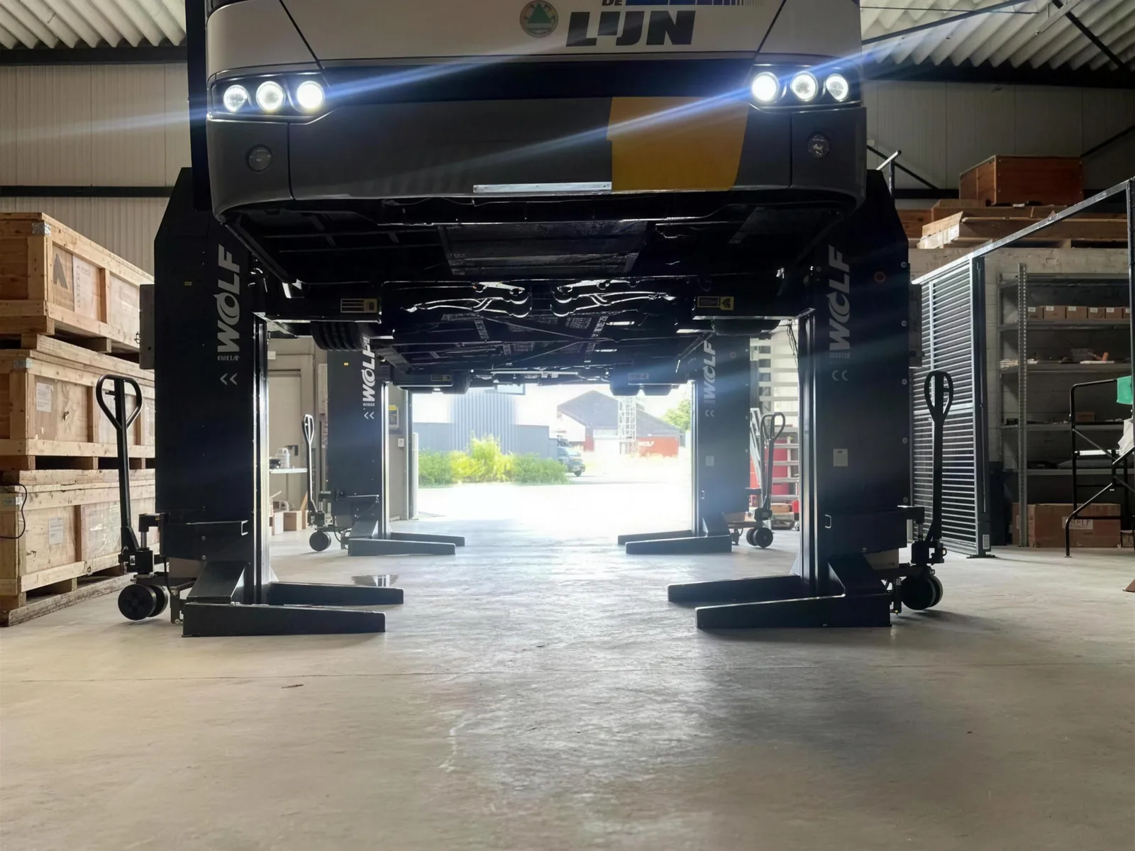 Electric bus raised on a lift in a YES-EU service workshop
